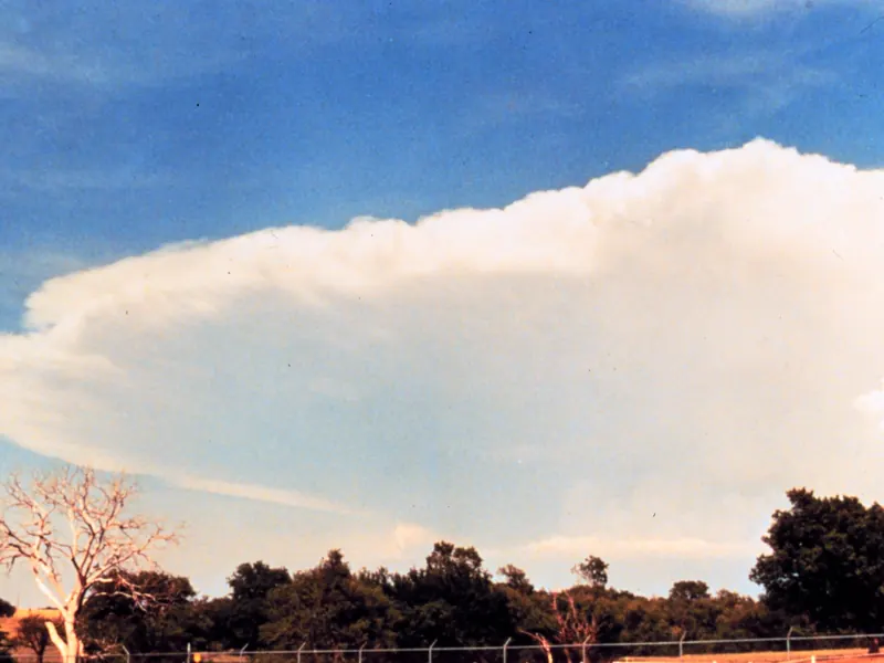 The huge flat-topped anvil of a towering storm cloud