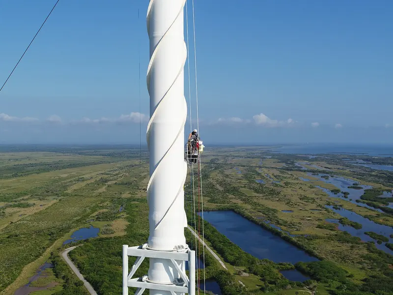A tall lightning protection tower beside a launch pad